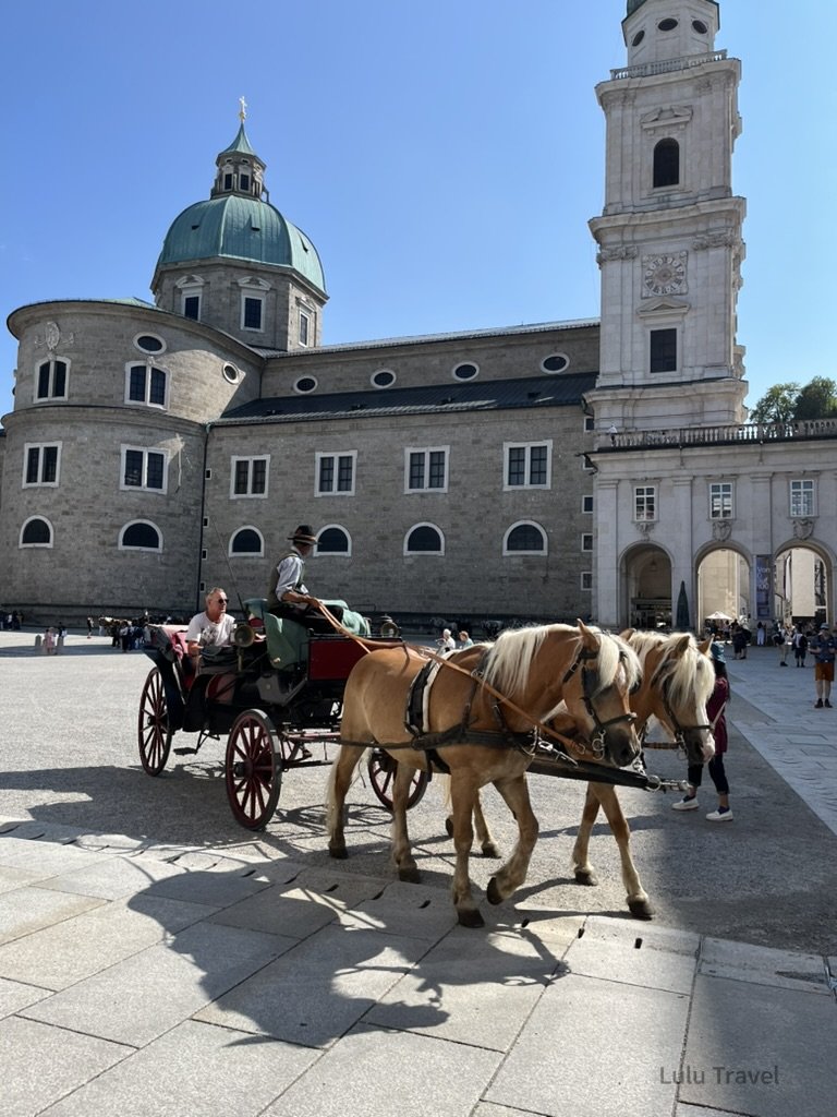 Traveling Europe with Elderly Family — Planning Logic and Honest Reflections 奧地利薩爾斯堡老城廣場景色,馬車行駛於歷史建築前,背景為薩爾斯堡主教座堂與舊城地標