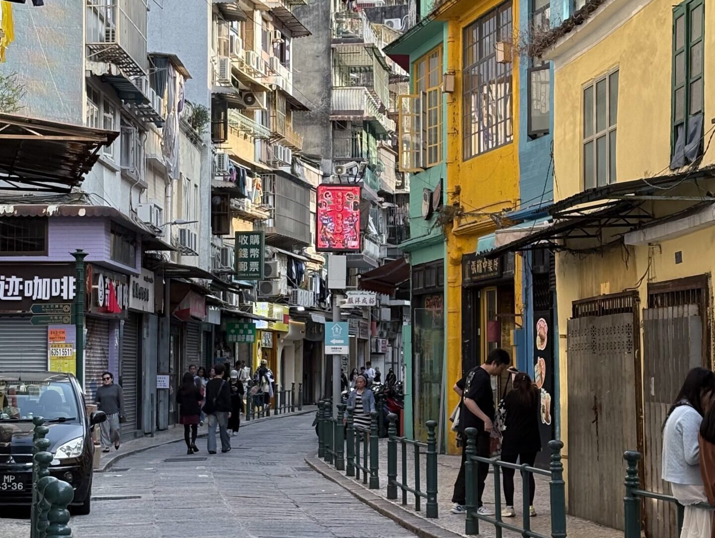 10+ Must-Eat Stalls in Macau: A No-Backtrack Food Route for 2 Days 1 Night 澳門舊城區彩色街屋與狹窄石板路,葡式建築立面交錯,呈現日常生活感的澳門街景