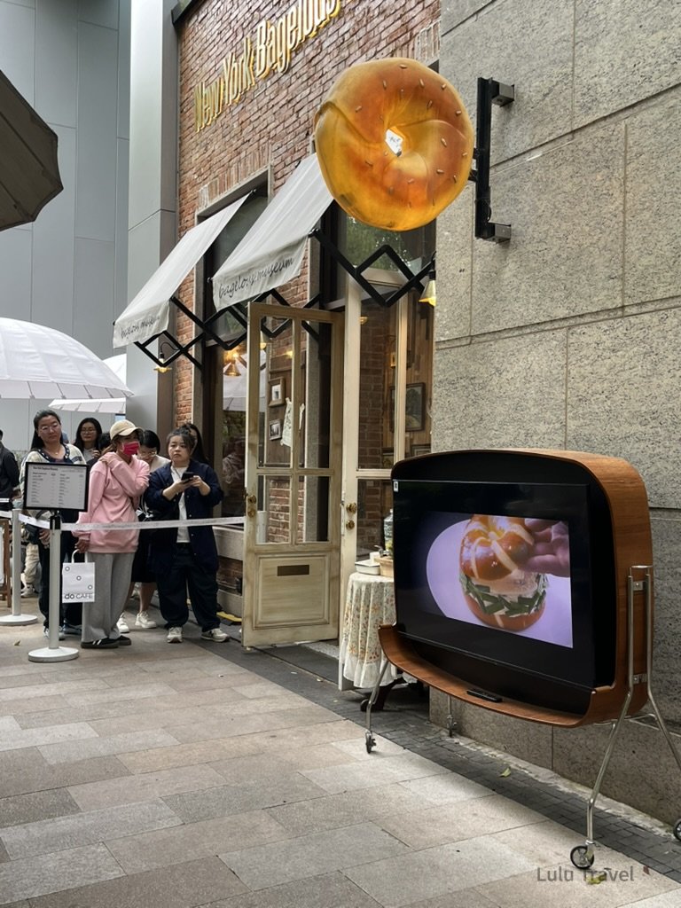 Shanghai City Walk — What I Got Wrong and What I'd Do Differently 上海貝果博物館外觀,巨型貝果招牌懸掛於立面,店外排隊人潮等候入場