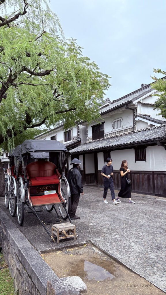 日本岡山倉敷美觀地區，傳統人力船行經石橋下，兩岸為白牆黑瓦的江戶時代街屋