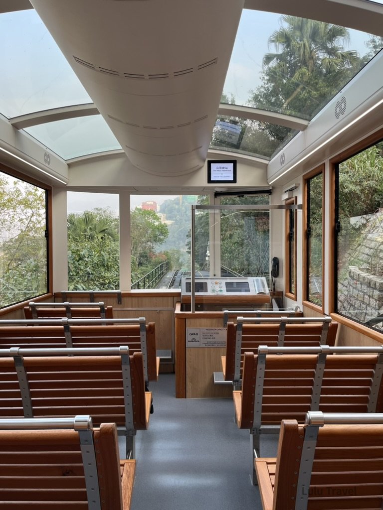 Hong Kong Trip Beyond the Surface: A Strategic 4-Day Itinerary 香港太平山纜車車廂內部視角,木質座椅與全景玻璃車頂設計,沿途可欣賞山林綠意與陡坡軌道,是前往太平山頂的經典交通體驗