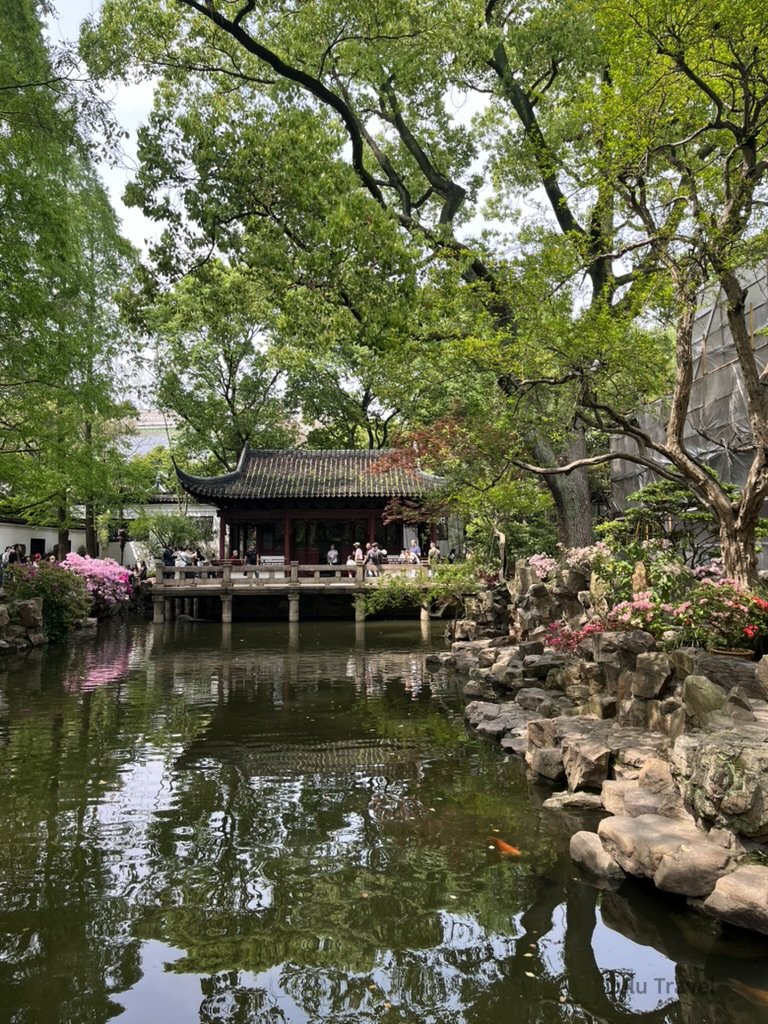 Shanghai City Walk — What I Got Wrong and What I'd Do Differently 上海豫園園景,傳統江南園林建築臨水而建,池塘、假山與綠樹環繞,遊客於園中漫步