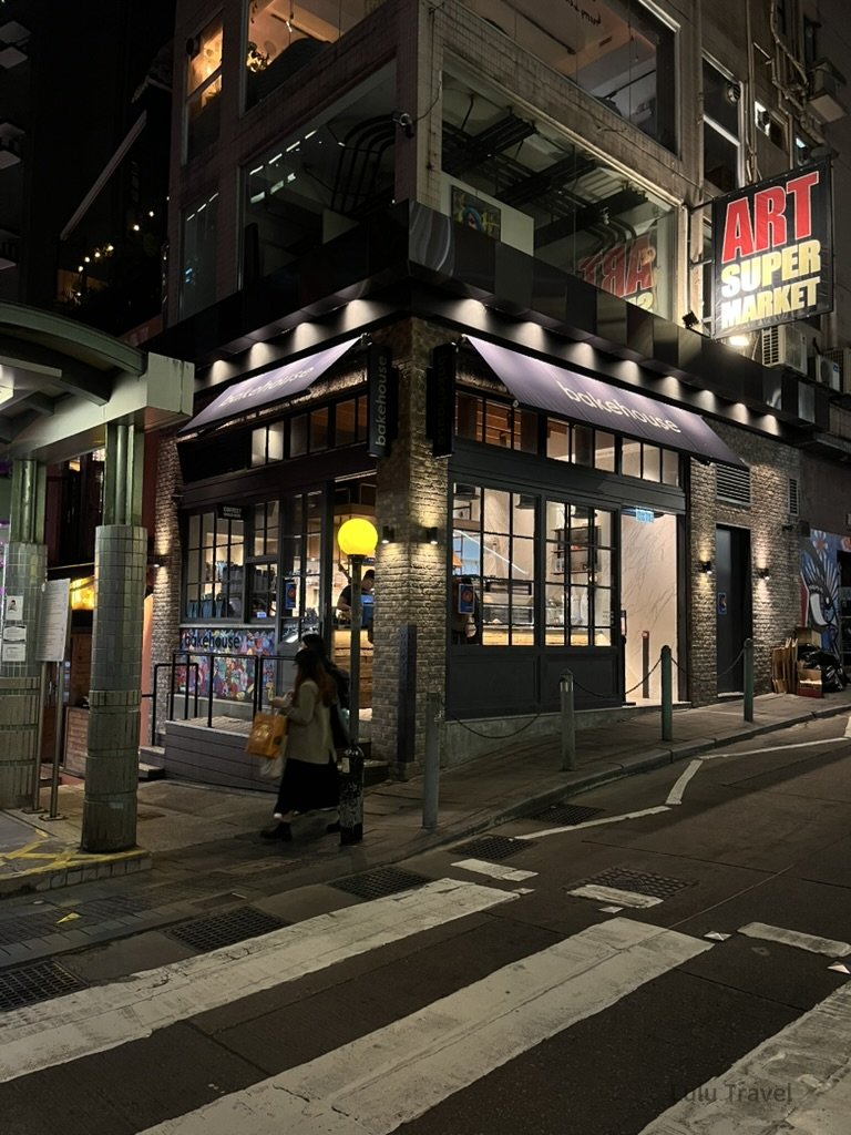 Hong Kong Trip Beyond the Surface: A Strategic 4-Day Itinerary 香港夜晚街景,轉角蛋塔店店外觀亮燈營業,結合復古建築與城市霓虹,是中環人氣甜點與散步路線之一