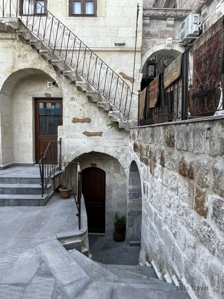 Turkey Group Tour: A Deep Dive into Culture and Itinerary Management 土耳其卡帕多奇亞洞穴飯店大廳,展現獨特的岩石牆面結構、幾何圓拱門設計與極具工業美學的石階與光影。