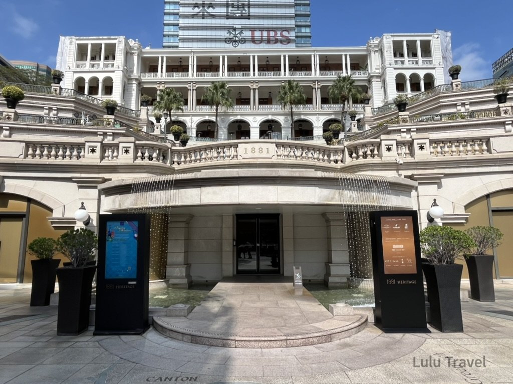Hong Kong Trip Beyond the Surface: A Strategic 4-Day Itinerary 香港中環 1881 Heritage 歷史建築正門外觀,白色殖民風格拱廊與階梯噴泉構成對稱立面,展現中環經典地標與現代商業大樓交融的城市景觀
