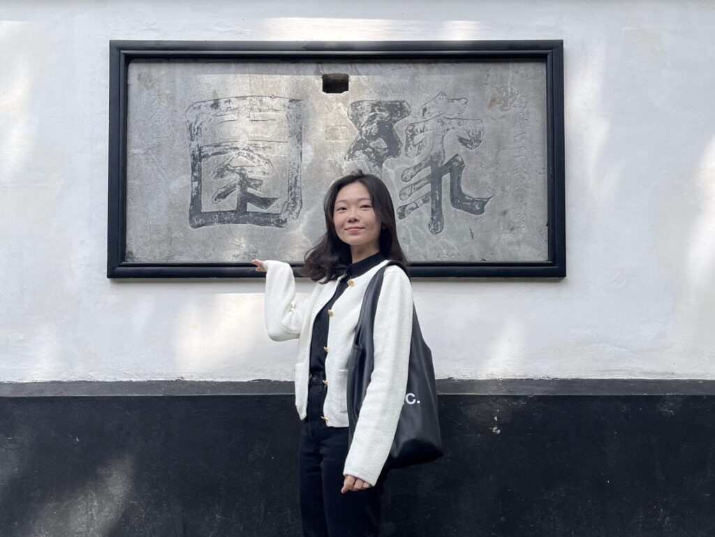 Shanghai City Walk — What I Got Wrong and What I'd Do Differently 上海豫園園區內,一名旅人站在刻有「豫園」字樣的石碑前合影,背景為白牆與傳統中式園林建築