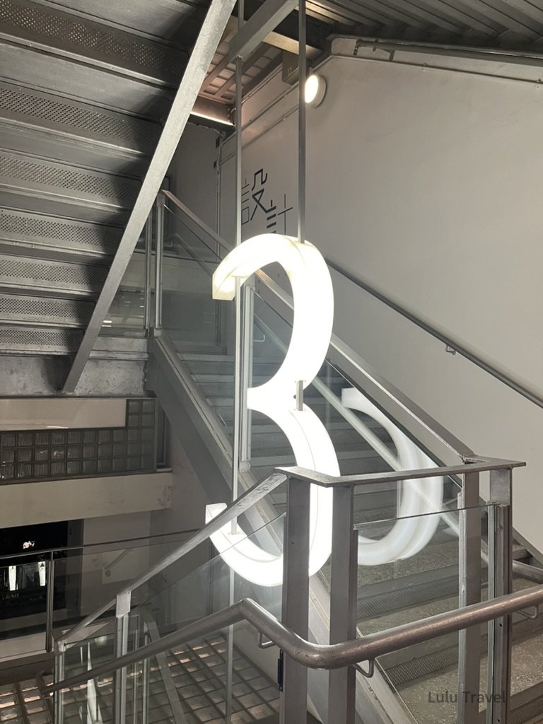 Hong Kong Trip Beyond the Surface: A Strategic 4-Day Itinerary 香港 PMQ 元創方室內樓梯空間,大型發光數字裝置結合工業風建築設計,展現香港設計場域特色