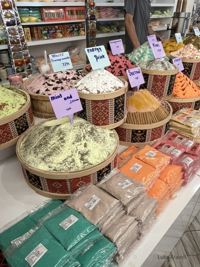 土耳其市場內排列整齊的粉末狀香料、乾果與蘇丹花茶，展現豐富的色彩對比與層次。