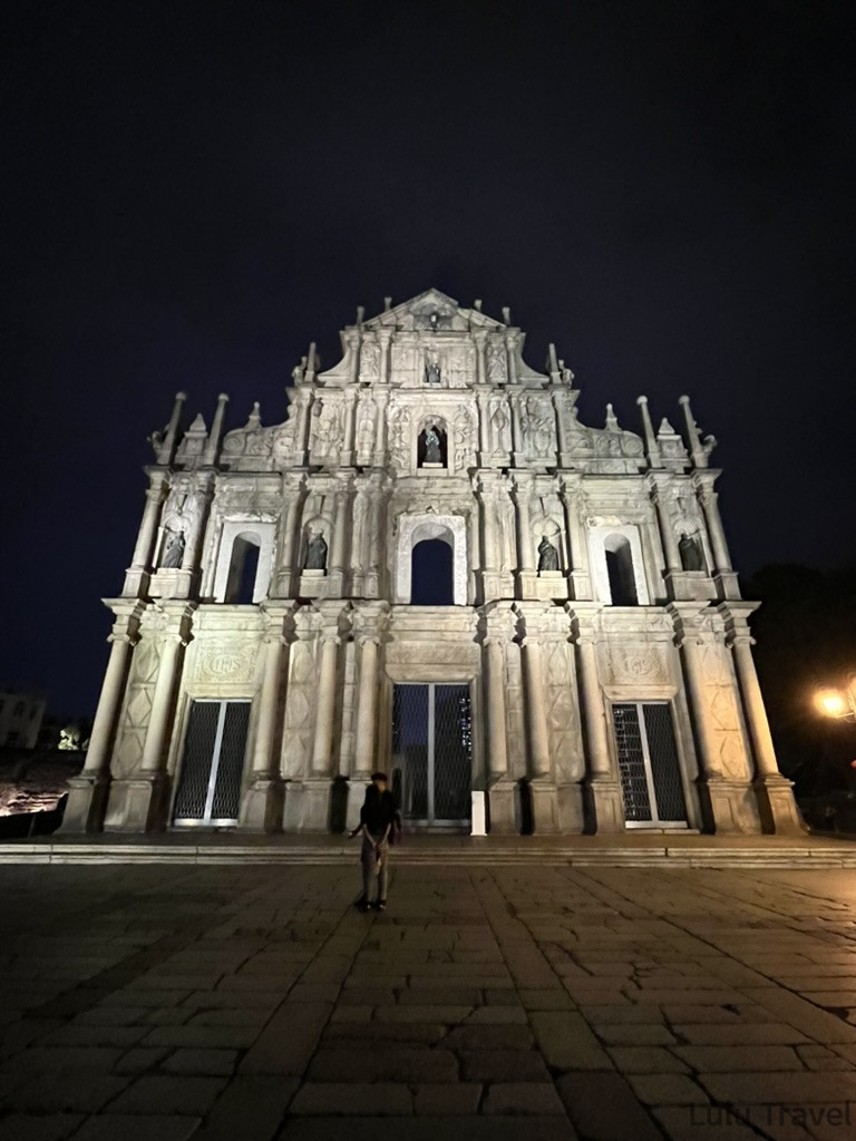 Accidental Macau Travel: A Spontaneous 2-Day Macau Self-Guided Itinerary 澳門大三巴夜景全貌,燈光照亮巴洛克風格石砌立面,石階上有遊客拍照留影