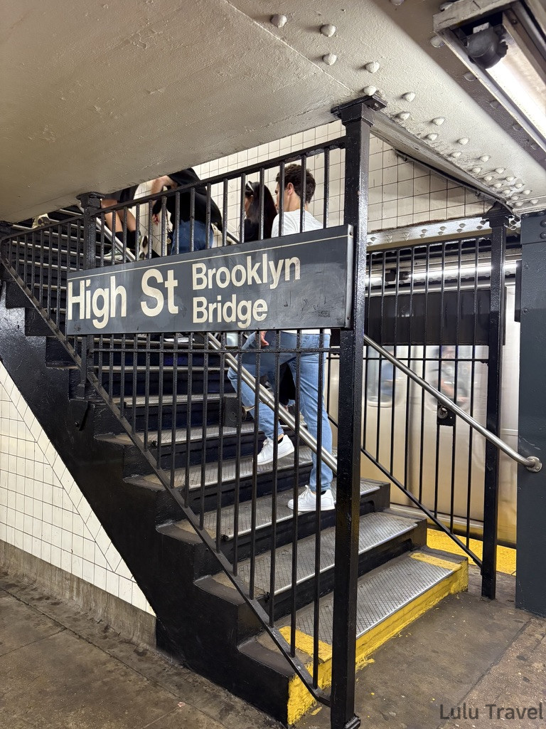 紐約自由行 | 旅費明細、交通技巧與住宿避雷全記錄 紐約地鐵 High St - Brooklyn Bridge 站出口階梯實況,標示牌明確導引前往布魯克林大橋方向,展現真實的車站內裝。