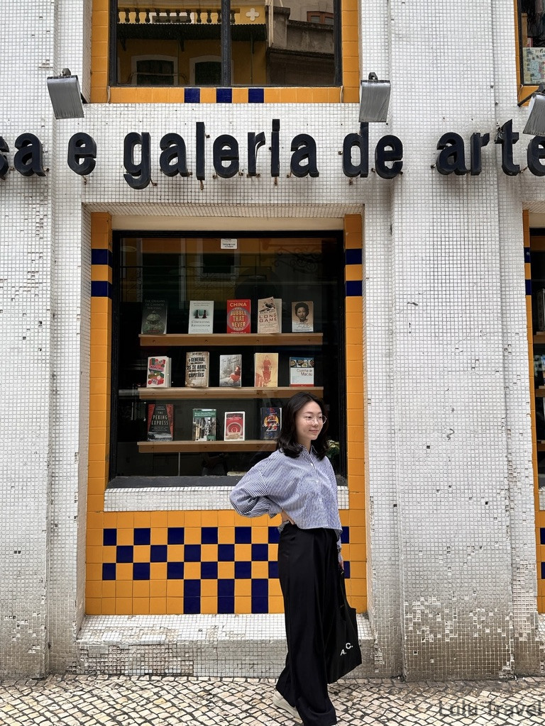 Accidental Macau Travel: A Spontaneous 2-Day Macau Self-Guided Itinerary 站在澳門葡文書局外牆前拍照,書局以橙黃藍色馬賽克磚拼成,書局內陳列英文書籍