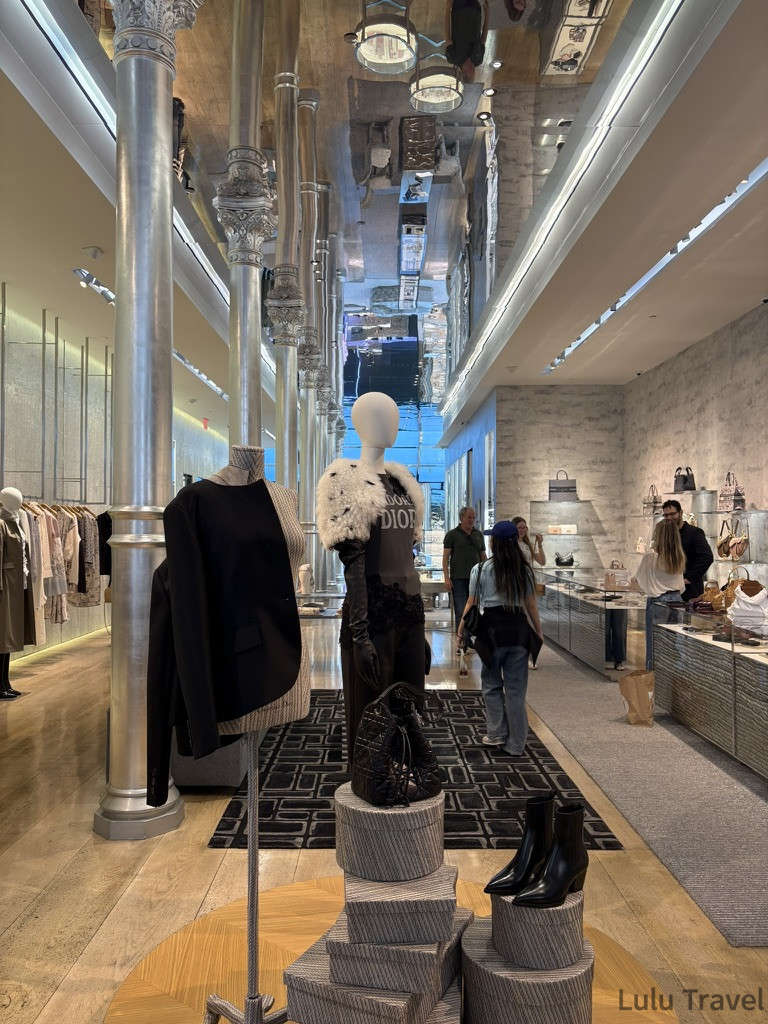 紐約行程規劃|DUMBO、百老匯、布魯克林到波士頓一日遊 紐約 SOHO 區 Dior 展間內部實拍,銀色金屬圓柱與鏡面天花板營造出極致的現代感,模特兒人台展示著品牌服飾,展現紐約時尚街區的室內設計尺度。