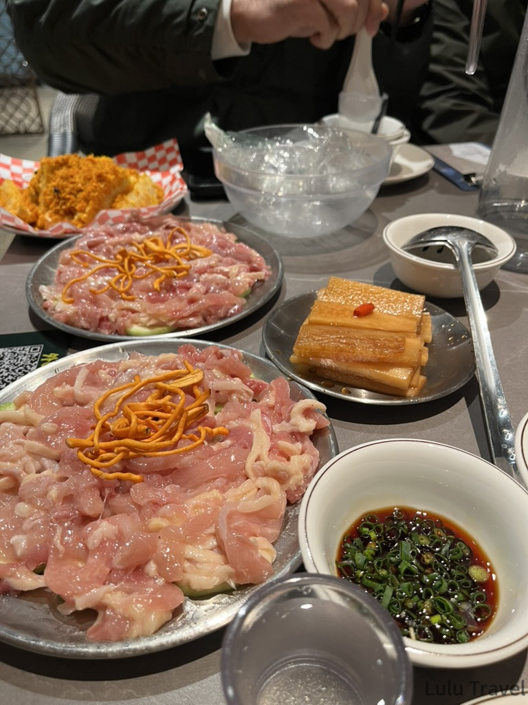 中國出差|深圳的震撼反差與義烏意外挖到的免費景點 中國出差應酬飯局桌上的生豬肉火鍋食材,大盤薄切豬肉片搭配金針菇,旁附醬油蔥花沾醬與滷筍乾