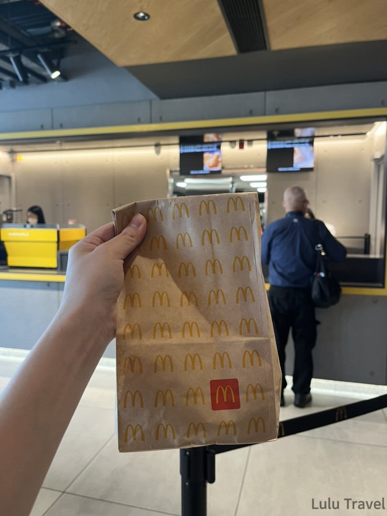 香港出差被迫多待一晚，深夜在住宅小區找到麥當勞，手持用八達通結帳得來的外帶袋，排隊等待飯店check in
