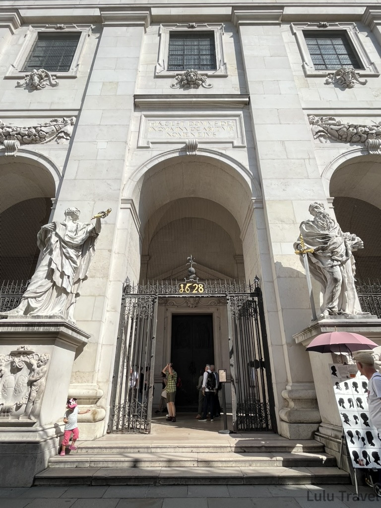 Salzburg Travel Guide — 5 Highlights and Why It's More Than a Mozart Stopover 薩爾斯堡主教座堂正面入口,白色巴洛克立面兩側各有聖人雕像,門上標示建造年份 1628