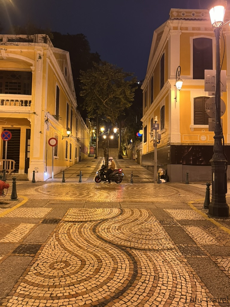 Accidental Macau Travel: A Spontaneous 2-Day Macau Self-Guided Itinerary 澳門半島夜晚的葡式圓石廣場,波浪紋石板地面反射路燈光芒,兩側為黃色葡式建築