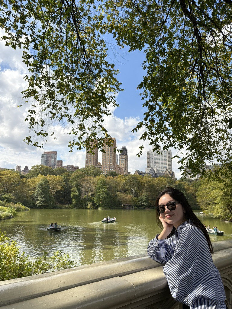 紐約自由行 | 旅費明細、交通技巧與住宿避雷全記錄 中央公園湖泊景觀,旅客倚靠欄杆欣賞對岸的聖雷莫公寓(The San Remo)雙子塔建築,湖面上有人正在划船,氣氛安靜從容。
