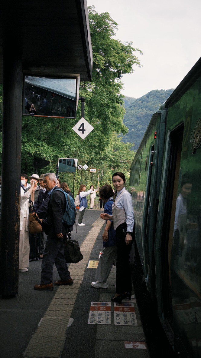福岡自由行|日本黃金週的6 天 5 夜行程與消費明細 由布院之森列車抵達月台,綠色復古的車身與站在車門旁穿著制服的親切站務員