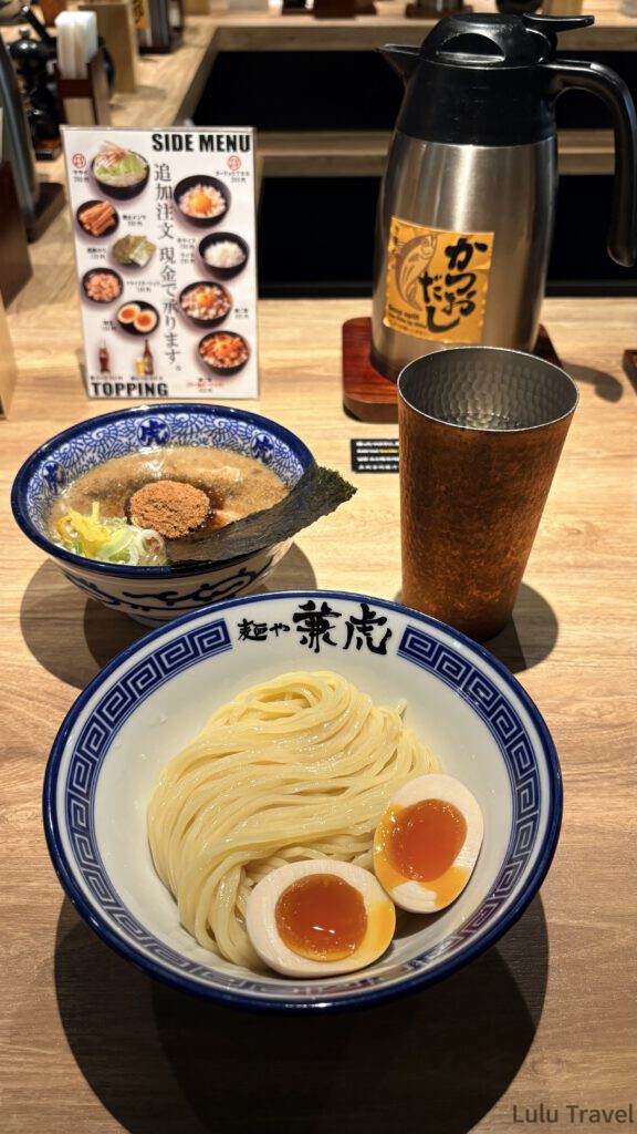 福岡自由行|日本黃金週的6 天 5 夜行程與消費明細 麵屋兼虎的沾麵實拍,一碗是粗麵條配上色澤鮮艷的溏心蛋,另一碗是灑滿魚粉的濃郁沾麵湯汁,桌上附有自助高湯壺
