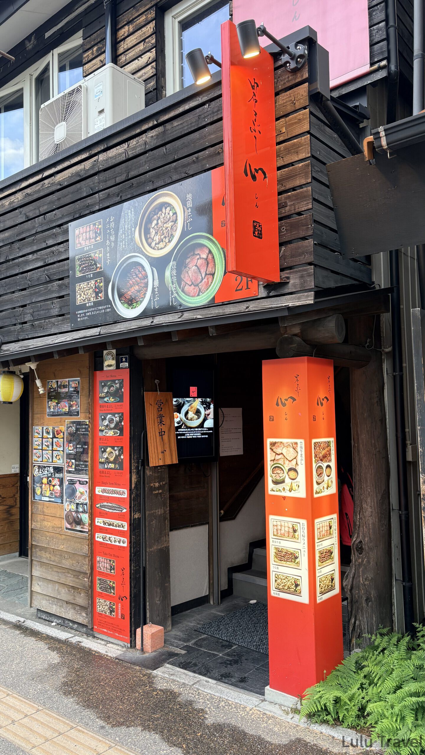 由布院兩天一夜|避開黃金週人潮的溫泉住宿與由布院之森 由布釜飯「心」湯布院站前店的店門口,紅色招牌與掛著營業中木牌的入口