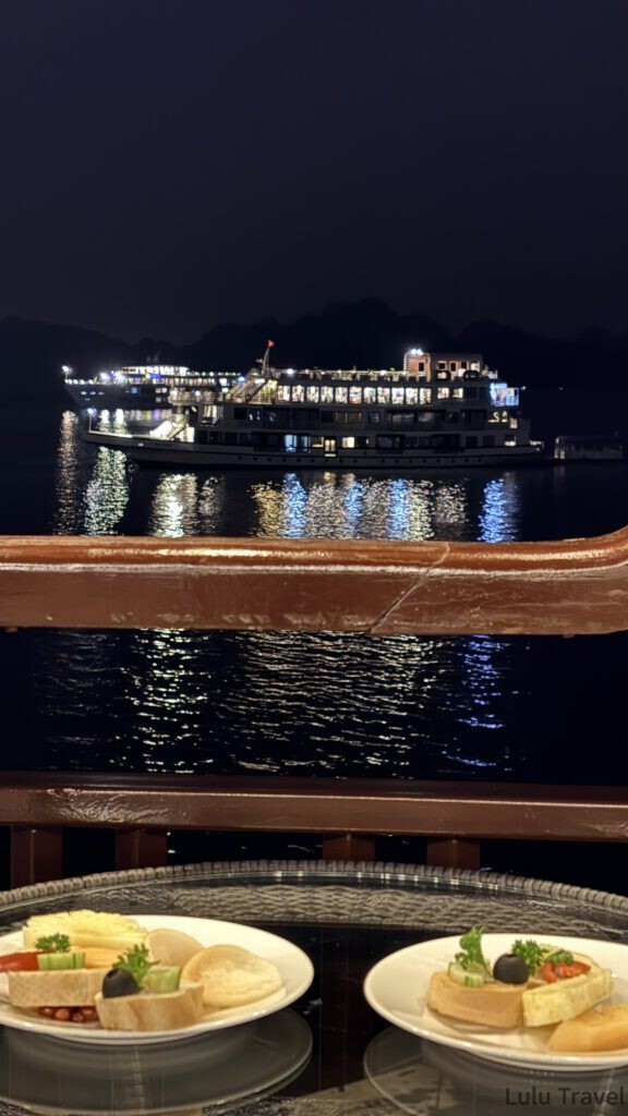 下龍灣郵輪|Amanda 兩天一夜實搭,4 家行程比較與體驗細節 從甲板餐桌望出去的夜間下龍灣,遠方郵輪亮著燈