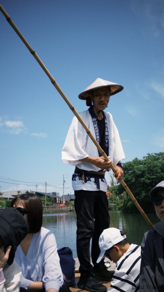 福岡自由行|日本黃金週的6 天 5 夜行程與消費明細 柳川遊船的船夫,戴著傳統斗笠、身穿印有柳川觀光開發的法被,正握著長竹竿為遊客撐船